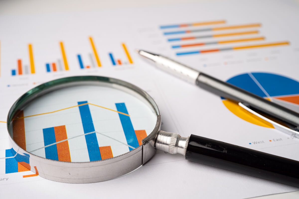 Magnifying glass over colorful graphs.